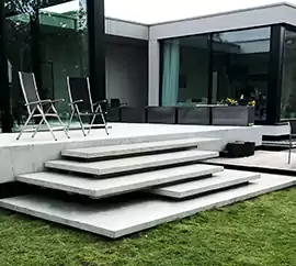 Schody zewnętrzne wykonane w nowoczesnej stylistyce, wykończenie w technologii betonu architektonicznego.